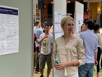 UVA Cell and Molecular Biology grad student standing proudly in front of her poster at poster session.
